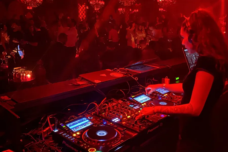Lily Rivers at the decks in a red-lit club